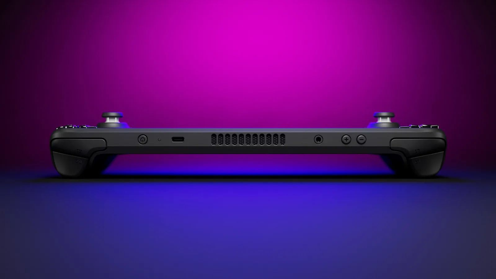 Rear view of a Steam Deck handheld lying flat under purple and blue studio lighting, showing its vents and shoulder buttons