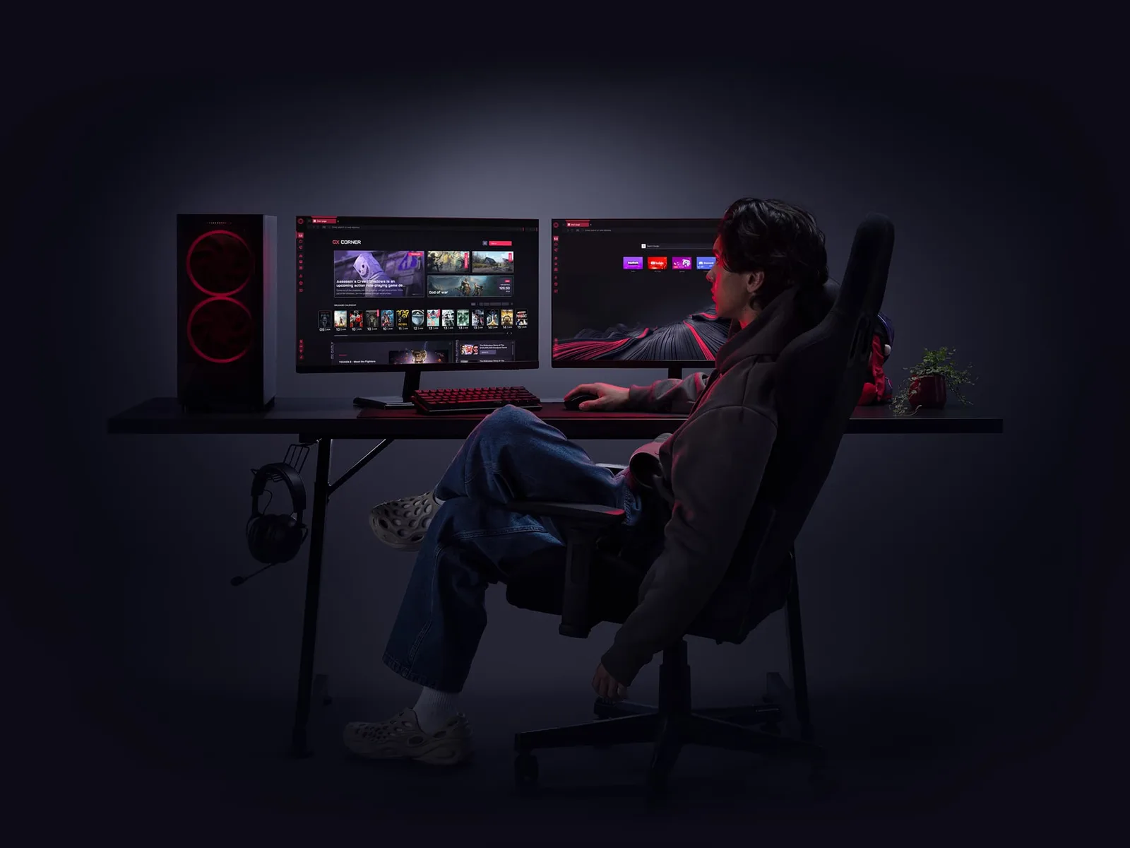 Gamer seated at a dark desk with a PC tower and two monitors showing the Opera GX browser, including its GX Corner page